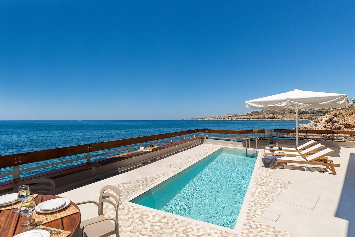 Pool deck at Kormoranos Waterfront Villa hanging over the sea near Chania